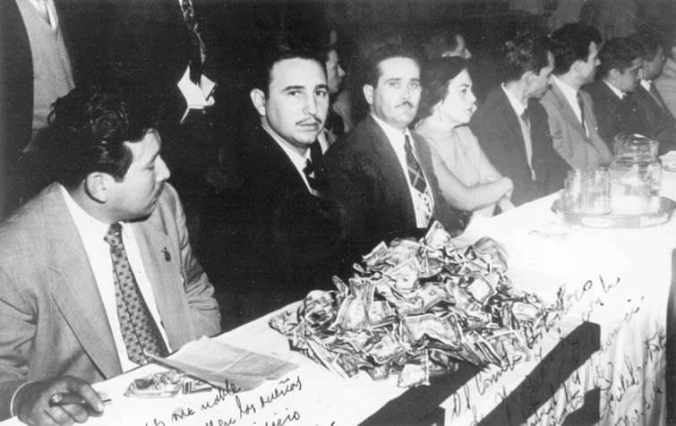 Durante el acto en el Palm Garden Hotel, aparece junto al también revolucionario Juan Manuel Márquez. La colecta de dinero donado por cubanos emigrados es uno de los objetivos del viaje. 