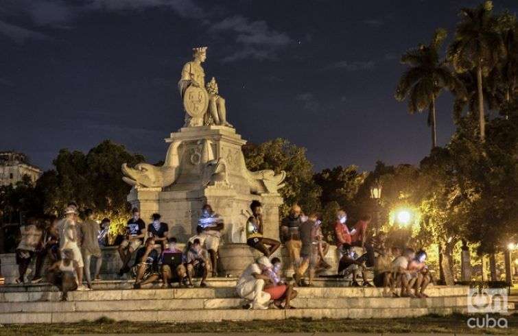 Cubanos conectados a la wifi de Etecsa en la Fuente de La India, en La Habana. Foto: Kaloian.