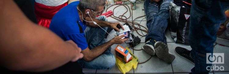 Un comercio local les presta la electricidad para que los cubanos puedan mantener cargados sus celulares. Foto: Irina Dambrauskas.