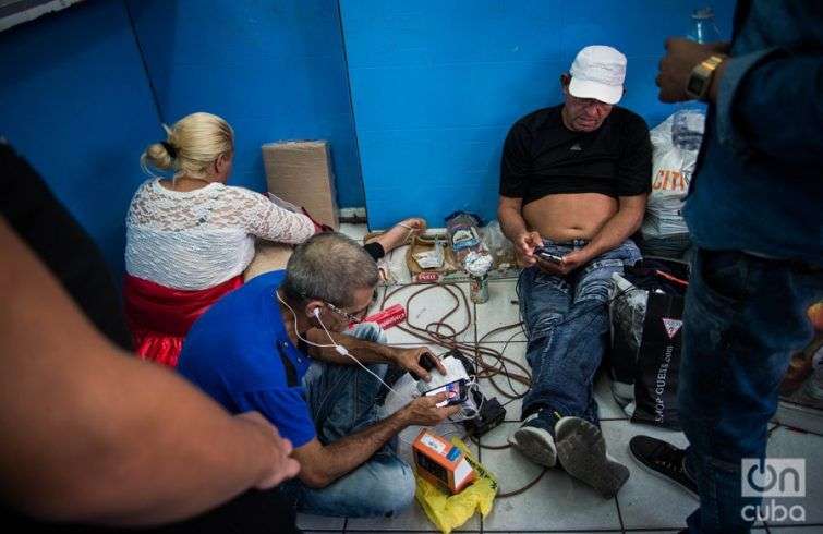 Un comercio local les presta la electricidad para que los cubanos puedan mantener cargados sus celulares. Foto: Irina Dambrauskas.