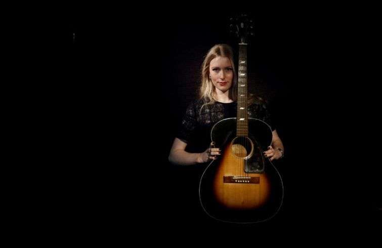 Una asistente de la casa de subastas londinense Bonhams enseña una guitarra acústica Epiphone FT79 utilizada y tocada por el músico estadounidense Jimi Hendrix. Foto: Stefan Wermuth/Reuters.