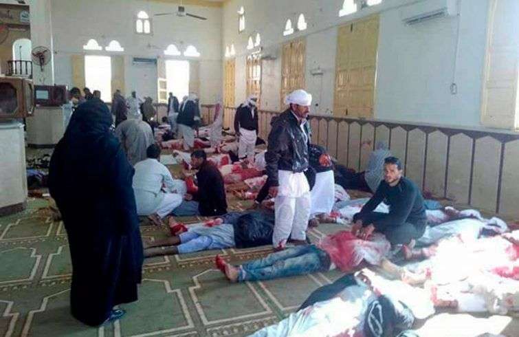Varias personas permanecen junto a cuerpos sin vida en el interior una mezquita contra la que se ha perpetrado un ataque, en la ciudad de Al Arish, en el norte de la península del Sinaí (Egipto), hoy. Foto: EFE.
