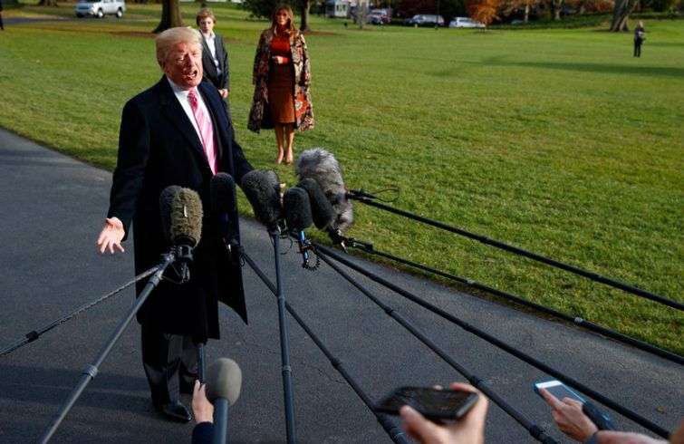 Donald Trump habla con la prensa al salir de la Casa Blanca, el 21 de noviembre de 2017, rumbo a Mar-a-Lago en Palm Beach, Florida, para el día de Acción de Gracias. La primera dama Melania Trump y el hijo de ambos, Barron, esperan atrás. Foto: Evan Vucci / AP.
