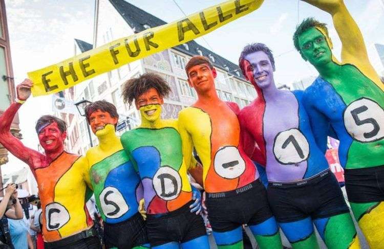 Manifestantes pintados con los colores del arcoiris con una pancarta que dice "Matrimonio para todos", en 2015. Foto: Efe.