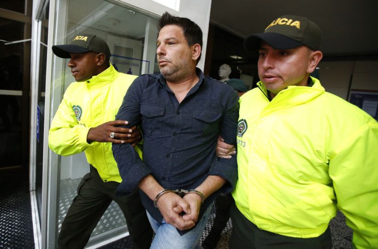 El cubano Raúl Gutiérrez conducido por dos policías tras su detención en Colombia en 2018, acusado de planear acciones terroristas. Foto: Fernando Vergara / AP / Archivo.