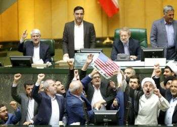 Legisladores iraníes queman dos papeles que representan una bandera de Estados Unidos y el acuerdo nuclear, mientras corean consignas contra Washington en el parlamento, en Teherán, el 9 de mayo de 2018. Foto: AP.