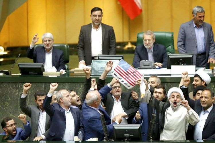 Legisladores iraníes queman dos papeles que representan una bandera de Estados Unidos y el acuerdo nuclear, mientras corean consignas contra Washington en el parlamento, en Teherán, el 9 de mayo de 2018. Foto: AP.