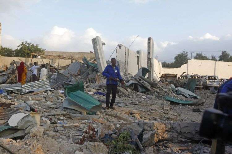 Soldados caminan entre vehículos destrozados y restos tras un doble ataque en la capital de Somalia, Mogadiscio. Foto: Farah Abdi Warsameh / AP.