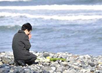 Una mujer reza hacia el mar en memoria de las víctimas del tsunami que hace 7 años cobró la vida de al menos 18,000 personas en Kesennuma, Japón. Foto: Iori Sagisawa / Kyodo News via AP.