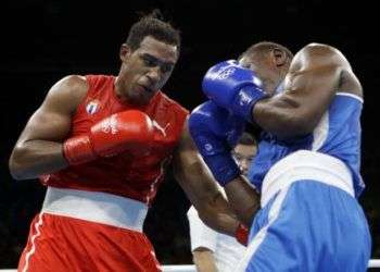 El cubano Arlen López lanza un gancho al hígado contra el francés Christian Mbili. Foto: Frank Franklin II / AP.