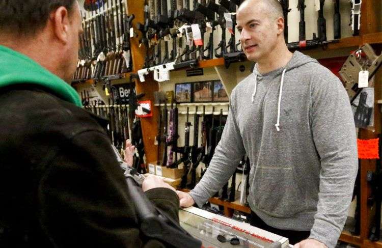 Wes Morosky, dueño de Duke's Sport Shop, asesora a Ron Detka, quien desea comprar un fusil, el 2 de marzo de 2018 en New Castle, EEUU. Foto: Keith Srakocic / AP.
