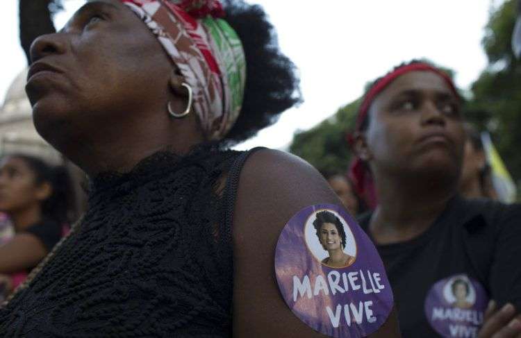 Una mujer porta una estampa con la imagen de la concejal Marielle Franco durante una protesta contra su asesinato en Río de Janeiro, Brasil. Foto: Leo Correa / AP.