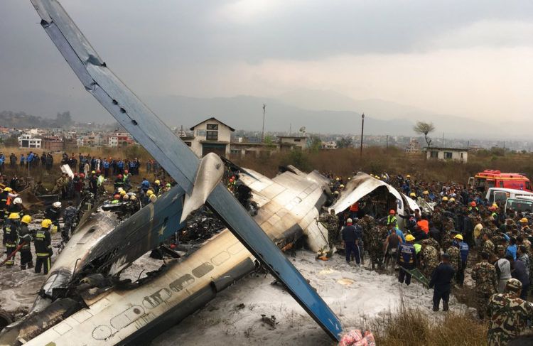 Rescatistas nepalíes junto a un avión de pasajeros de Bangladesh estrellado en el aeropuerto de Katmandú, en Nepal. Foto: Niranjan Shreshta / AP.