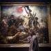 Una mujer mira la pintura "La liberté guidant le peuple" de Eugène Delacroix en el Museo del Louvre en París. Foto: Christophe Ena / AP.