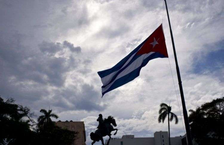 Bandera cubana ondea a media asta cerca de la estatua de José Martí al inicio de dos días de luto en Cuba, el 19 de mayo de 2018. Foto: Ramón Espinosa / AP.