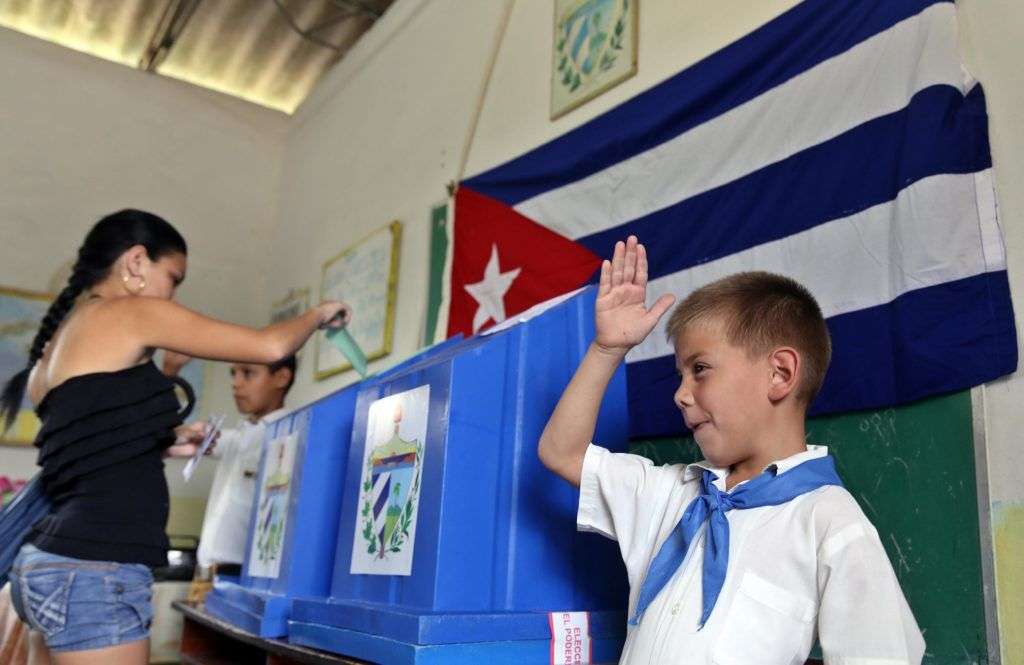 Un niño saluda mientras una mujer vota en las elecciones en Cuba. Foto: Alejandro Ernesto / EFE / Archivo.