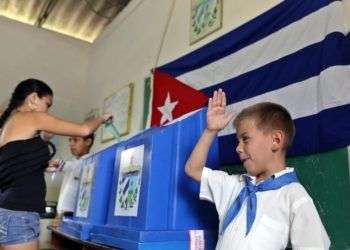 Un niño saluda mientras una mujer vota en las elecciones en Cuba. Foto: Alejandro Ernesto / EFE / Archivo.
