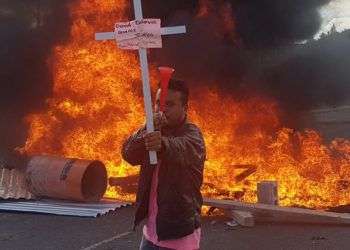 Manifestante muestra una cruz con el nombre de una de las víctimas de las represiones militares. Inicia la movilización de protesta contra toma de posesión de Juan Orlando Hernández. Foto: Twitter de Gilda Silvestrucci, Corresponsal en Honduras de Telesur.