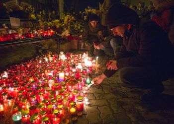 Las personas encienden velas en un homenaje improvisado a las víctimas de un incendio en un centro comercial en la ciudad siberiana de Kemerovo, en Rusia. Foto: Sergei Gavrilenko / AP.