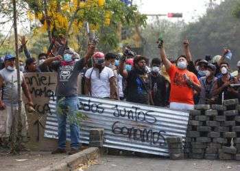 Un grupo de manifestantes lanza consignas tras bloquear una calle en un confrontamiento con las fuerzas de seguridad cerca de la Universidad Politécnica de Nicaragua (UPOLI) en Managua, el sábado 21 de abril. Foto: Alfredo Zúñiga / AP.
