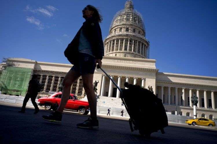 Una turista camina con su maleta por delante del Capitolio, en La Habana, Cuba. Foto: Ramón Espinosa / AP.