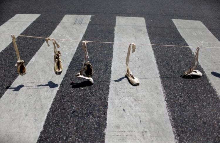 Zapatillas de ballet cuelgan de una soga como parte de una protesta contra la reciente decisión de reducir los fondos para la compañía de danza estatal, en Buenos Aires, Argentina. Foto: Natacha Pisarenko / AP.