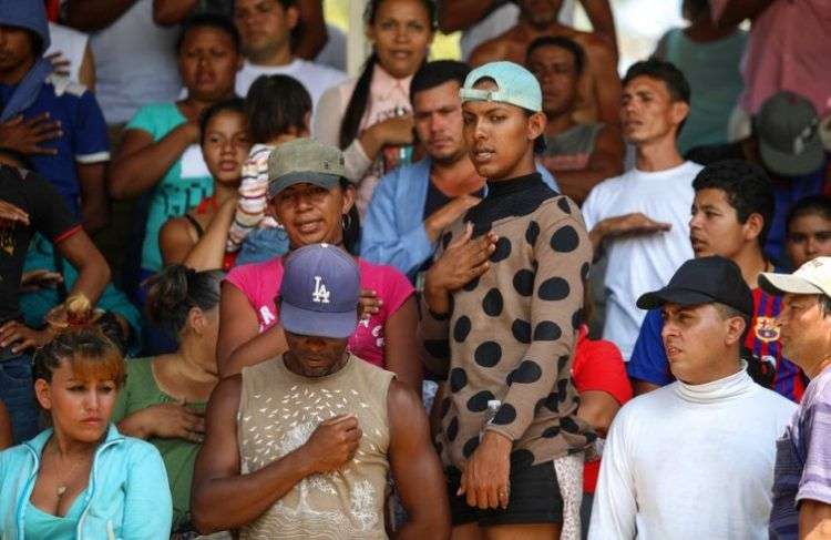 Hondureños cantan su himno nacional durante la caravana Viacrucis Migrante organizada por el grupo activista Pueblo Sin Fronteras en Matías Romero, estado de Oaxaca, en México, el lunes 2 de abril de 2018. Foto: Félix Márquez / AP.