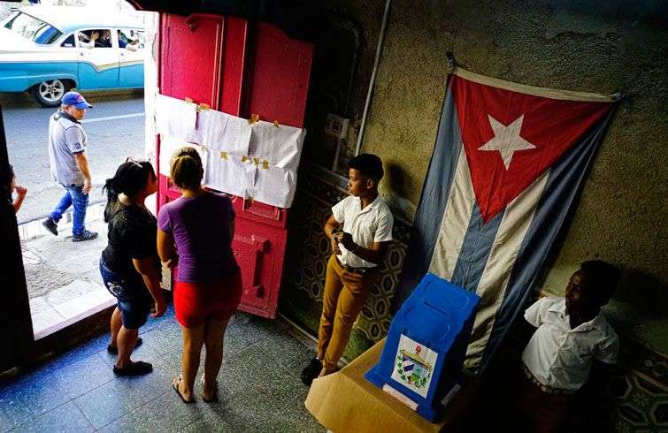 Dos mujeres buscan sus nombres en una lista de electores en un centro de votación durante los comicios municipales en La Habana este domingo 26 de noviembre. Foto: Ramón Espinosa / AP.