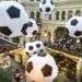 Turistas y aficionados del fútbol caminan por el centro comercial GUM decorado con enormes balones de fútbol con motivo del Mundial en Moscú, Rusia. Foto: Alexander Zemlianichenko/AP.