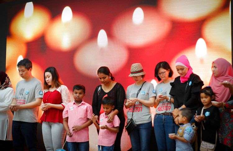 Familiares de los pasajeros del vuelo MH370 de Malaysia Airlines guardan un momento de silencio durante un homenaje en Kuala Lumpur, el 3 de marzo de 2018. El acto conmemora el cuarto aniversario de la desaparición del avión el 8 de marzo de 2014. Foto: Vincent Thian / AP.