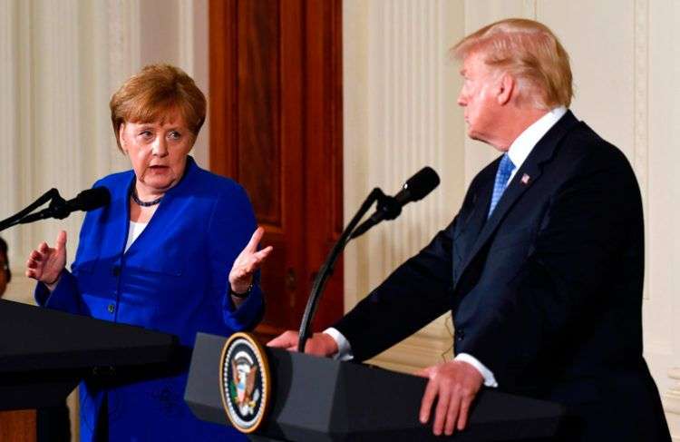 Donald Trump escucha a la canciller alemana Angela Merkel durante una conferencia de prensa conjunta en la Casa Blanca este viernes 27 de abril de 2018. Foto: Susan Walsh / AP.