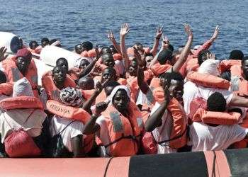 Migrantes saludan durante su traslado del barco Aquarius a otro de la Guardia Costera italiana, en el Mar Mediterráneo. Foto: Kenny Karpov / SOS Mediterranee vía AP.