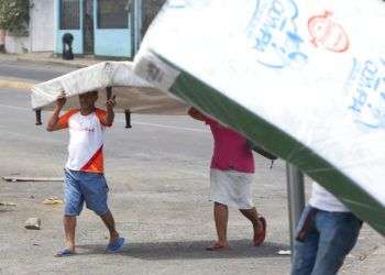 Varias personas se alejan con colchones que acaban de robar de una tienda en Managua, Nicaragua, el domingo 22 de abril de 2018. (AP Foto/Alfredo Zúñiga)