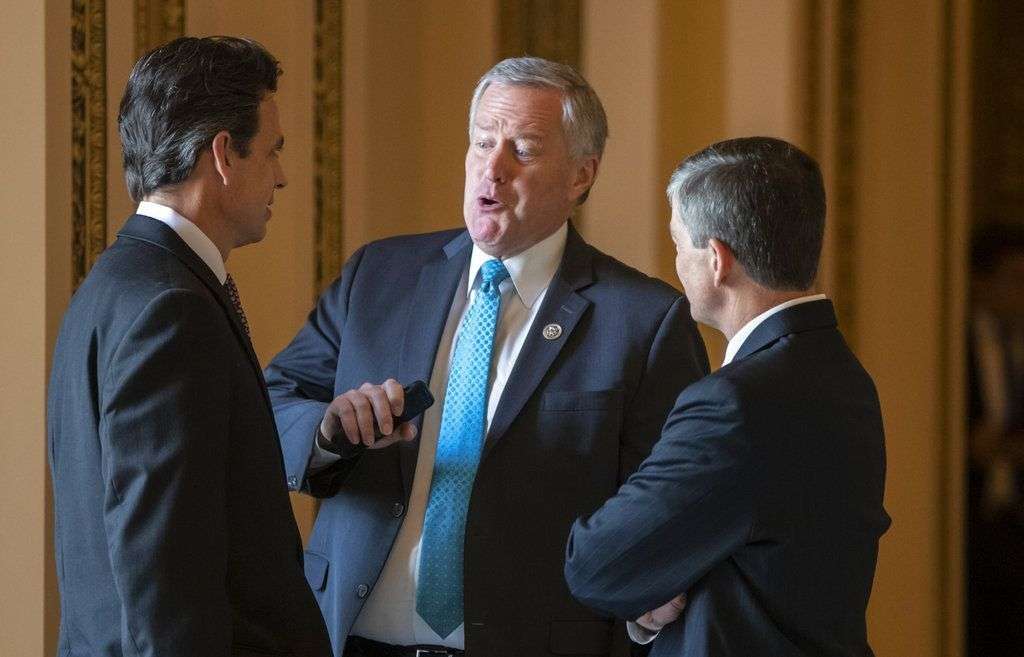 El representante republicano Mark Meadows (al centro) conversa con sus colegas y copartidarios Tom Graves y Jeb Hensarling antes de varias votaciones en la Cámara de Representantes, en Washington DC, el jueves 21 de junio de 2018. Foto: J. Scott Applewhite/AP.