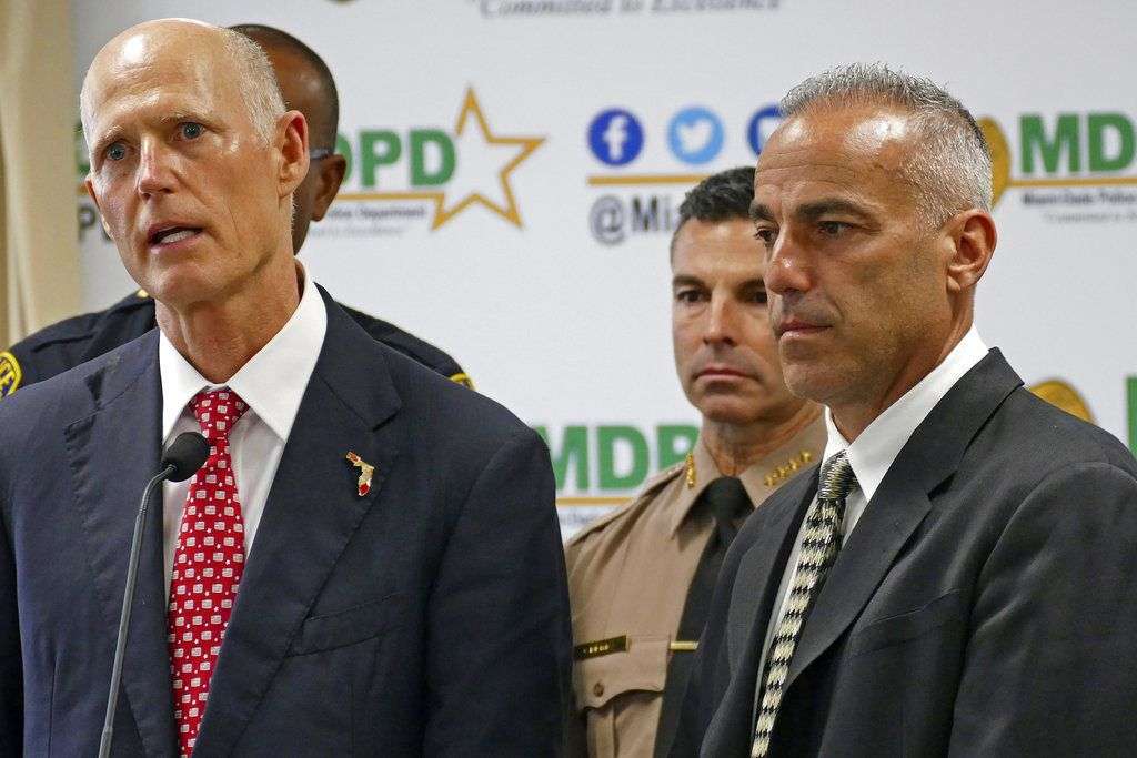 El gobernador de Florida, Rick Scott, izquierda, habla junto a Andrew Pollack, cuya hija Meadow murió en la masacre en una escuela en Parkland, en una conferencia de prensa en el Departamento de Policía de Miami-Dade, en febrero del 2018. Foto: C.M. Guerrero / Miami Herald vía AP.