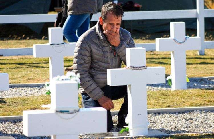 El familiar de un soldado argentino muerto durante la guerra de 1982 entre Argentina y Gran Bretaña en el cementerio militar de Darwin en las Islas Malvinas este lunes 26 de marzo de 2018. Foto: Caiti Beattie / AP.