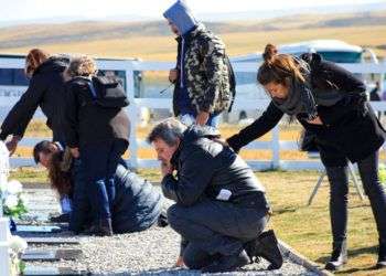 Familiares de soldados argentinos muertos durante la guerra de 1982 entre Argentina y Gran Bretaña visitan el cementerio militar de Darwin en las Islas Malvinas o Falkland, este lunes 26 de marzo de 2018. Foto: Caiti Beattie / AP.