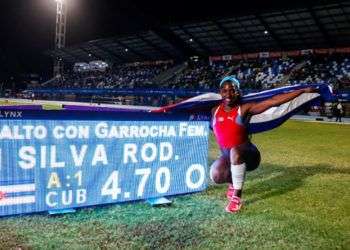 La pertiguista cubana Yarisley Silva posa junto a su récord en salto con pértiga del atletismo en los Juegos Centroamericanos de Barranquilla. Foto: Calixto N. Llanes / JIT.