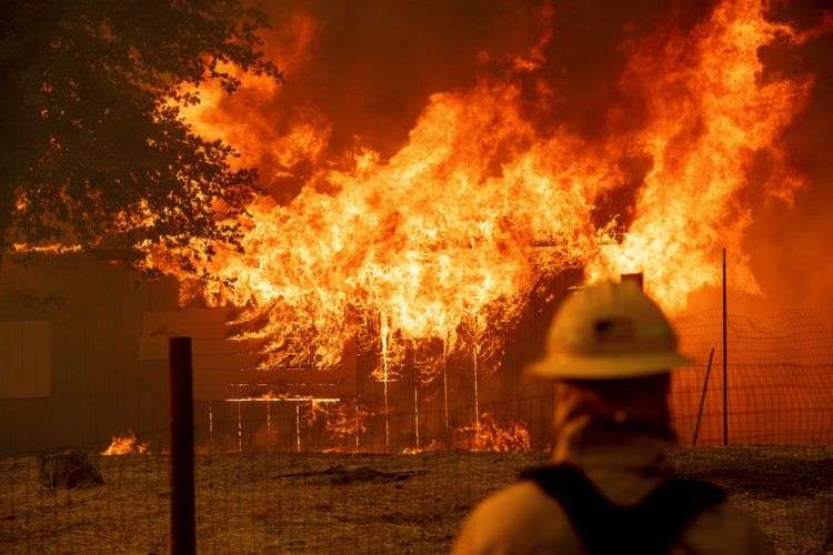 Un bombero controla un edificio en llamas para asegurarse de que no se expandan mientras el incendio River calcina parte de la ciudad de Lakeport, en California, el 30 de julio de 2018. Foto: Noah Berger / AP.