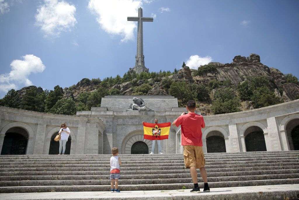 Un hombre posa con una bandera preconstitucional en el Valle de los Caídos, en El Escorial, a las afueras de Madrid. Foto: Andrea Comas / AP.