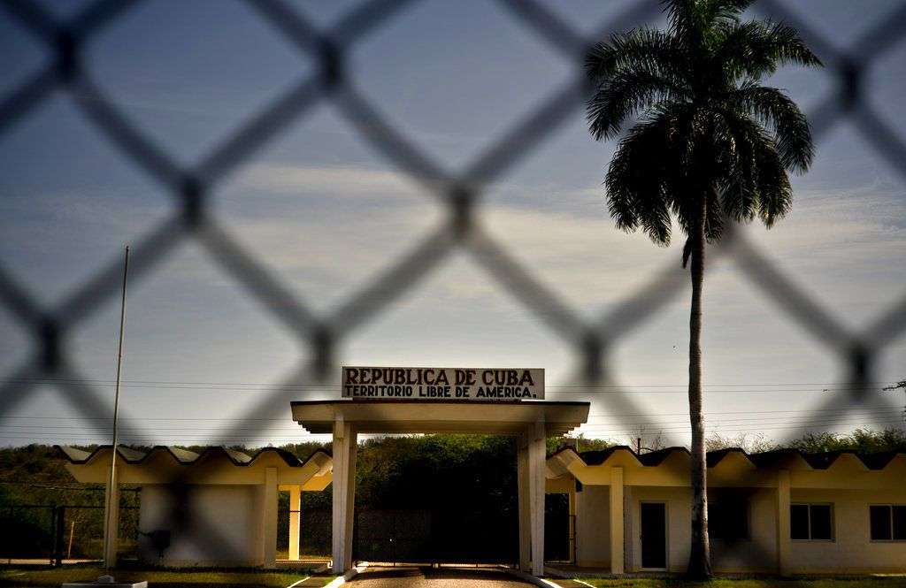 Un edificio con la leyenda "República de Cuba. Territorio Libre de América", detrás de una valla que marca la frontera con la Base Naval de Estados Unidos en la Bahía de Guantánamo. Foto: Ramón Espinosa / AP.