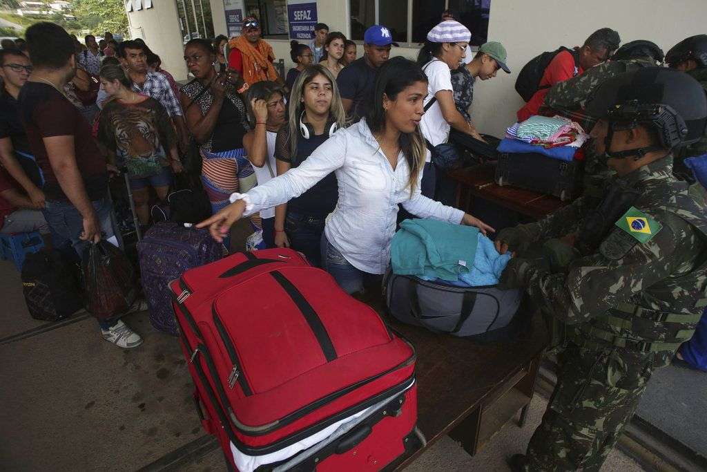 Venezolanos en un control fronterizo de la ciudad de Pacaraima, en el estado de Roraima, Brasil. El martes 7 de agosto del mismo año uno de los principales cruces fronterizos entre ambos países fue reabierto después de que estuvo cerrado casi un día por una disputa legal. Foto: Eraldo Peres / AP.