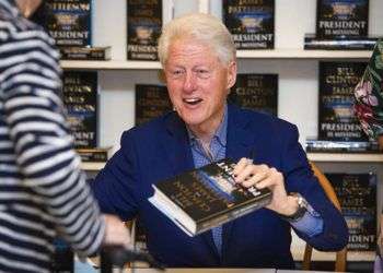 El presidente Bill Clinton sostiene una copia de “The President is Missing” en Book Revue, en Huntington, Nueva York. Foto: Scott Roth / Invision / AP / Archivo.
