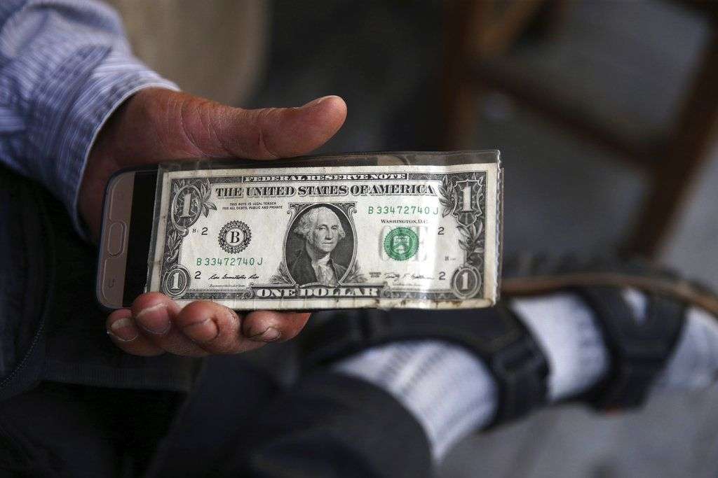 Un iraní sostiene un dólar estadounidense en Teherán, Irán. En momentos en los que Estados Unidos se dispone a reimponer sanciones a Irán que fueron levantadas bajo el acuerdo nuclear de 2015, sus aliados europeos temen una inestabilidad más grande en la región. Foto: Vahid Salemi/AP.