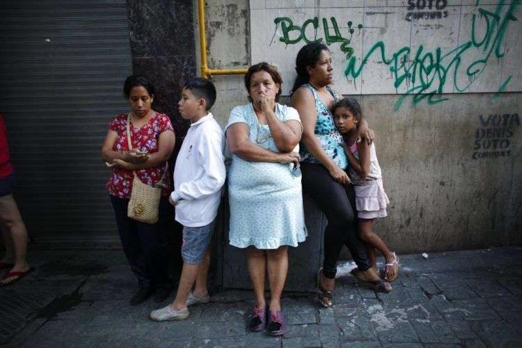 Residentes se detienen en la calle luego de que un fuerte sismo sacudiera el este de Venezuela y provocara la evacuación de edificios en Caracas, Venezuela, el martes 21 de agosto de 2018. Foto: Ariana Cubillos/AP.