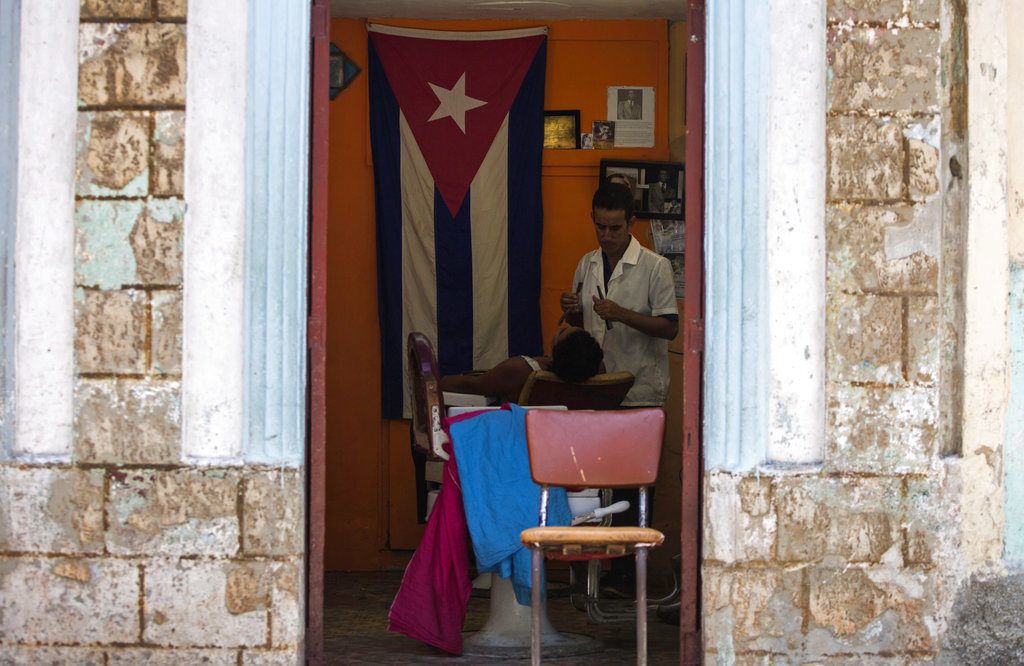 Un barbero rasura a un cliente en su negocio privado en La Habana, Cuba, el martes 10 de julio de 2018. Foto: Desmond Boylan / AP.