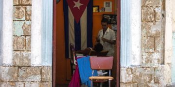 Un barbero rasura a un cliente en su negocio privado en La Habana, Cuba, el martes 10 de julio de 2018. Foto: Desmond Boylan / AP.