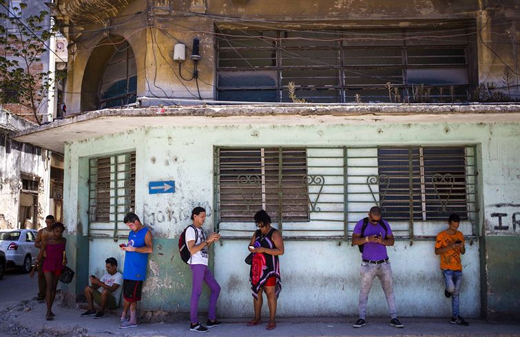Cubanos usan su teléfono para navegar en internet en La Habana, el miércoles 22 de agosto de 2018 en una prueba realizada por ETECSA. Foto: Desmond Boylan / AP.