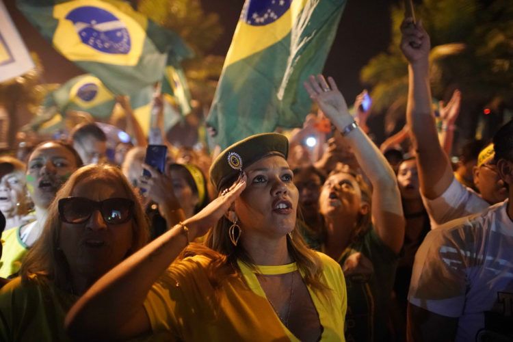 Una simpatizante de Jair Bolsonaro saluda durante la celebración de su triunfo en las elecciones presidenciales afuera de la residencia del candidato en Río de Janeiro, Brasil, el 28 de octubre de 2018. Foto: Leo Correa / AP.