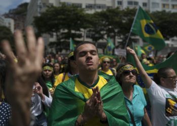 Una multitud escucha el himno nacional en el acto de campaña del candidato presidencial ultraderechista Jair Bolsonaro en Río de Janeiro, el domingo 21 de octubre de 2018. Foto: Leo Correa / AP.